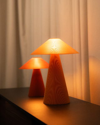 Dos lámparas de mesa encendidas, fotografiadas como bodegón de producto